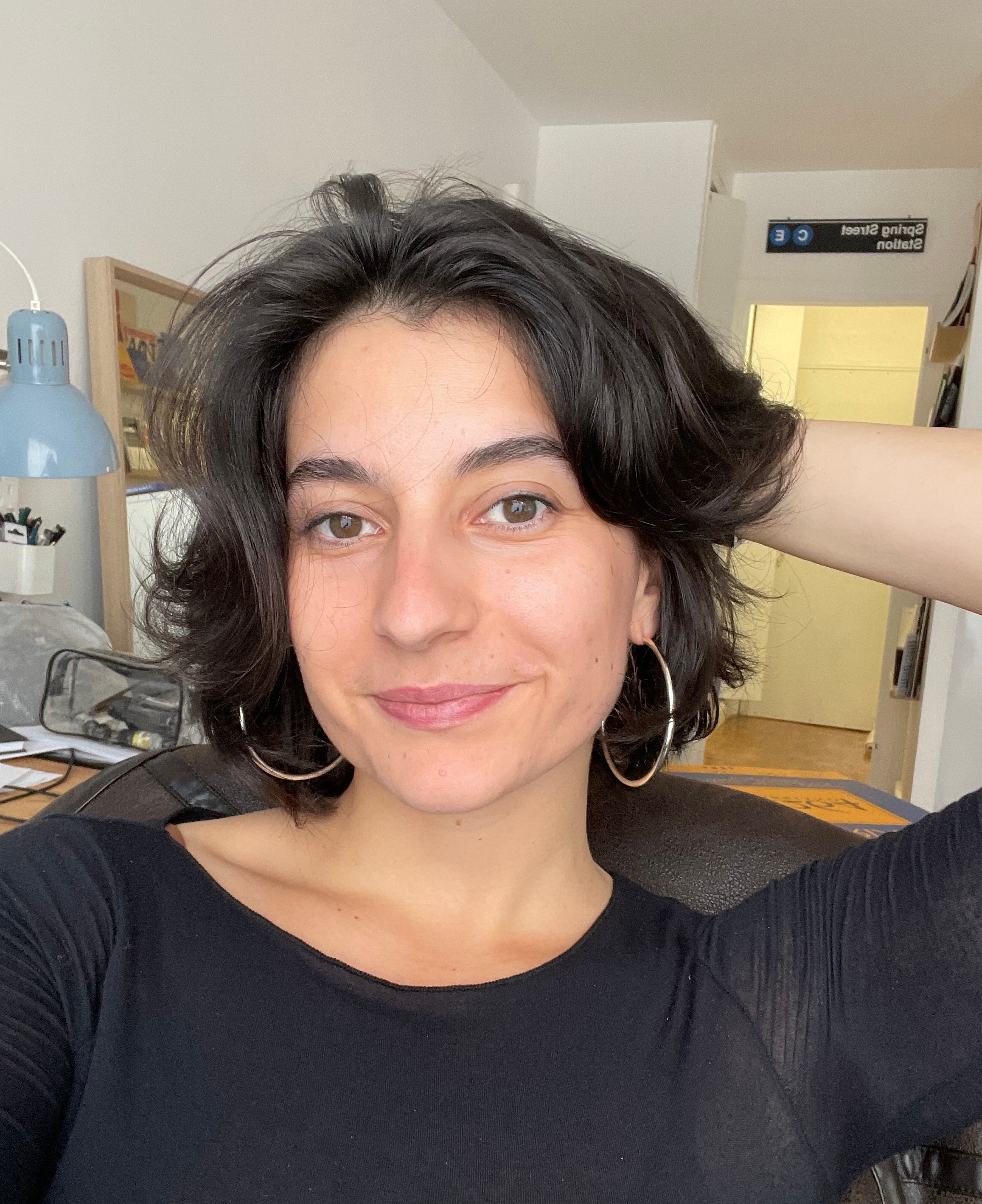 Portrait of a woman with brown hair on a flat gray background.