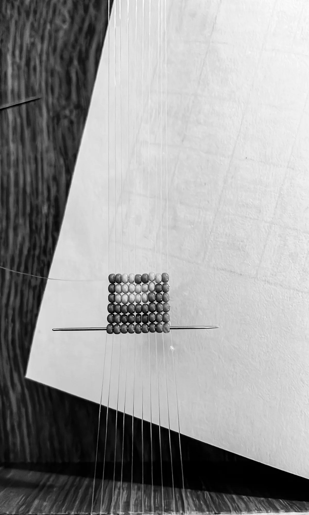 Petit tissage de perles bleues sur une feuille de papier