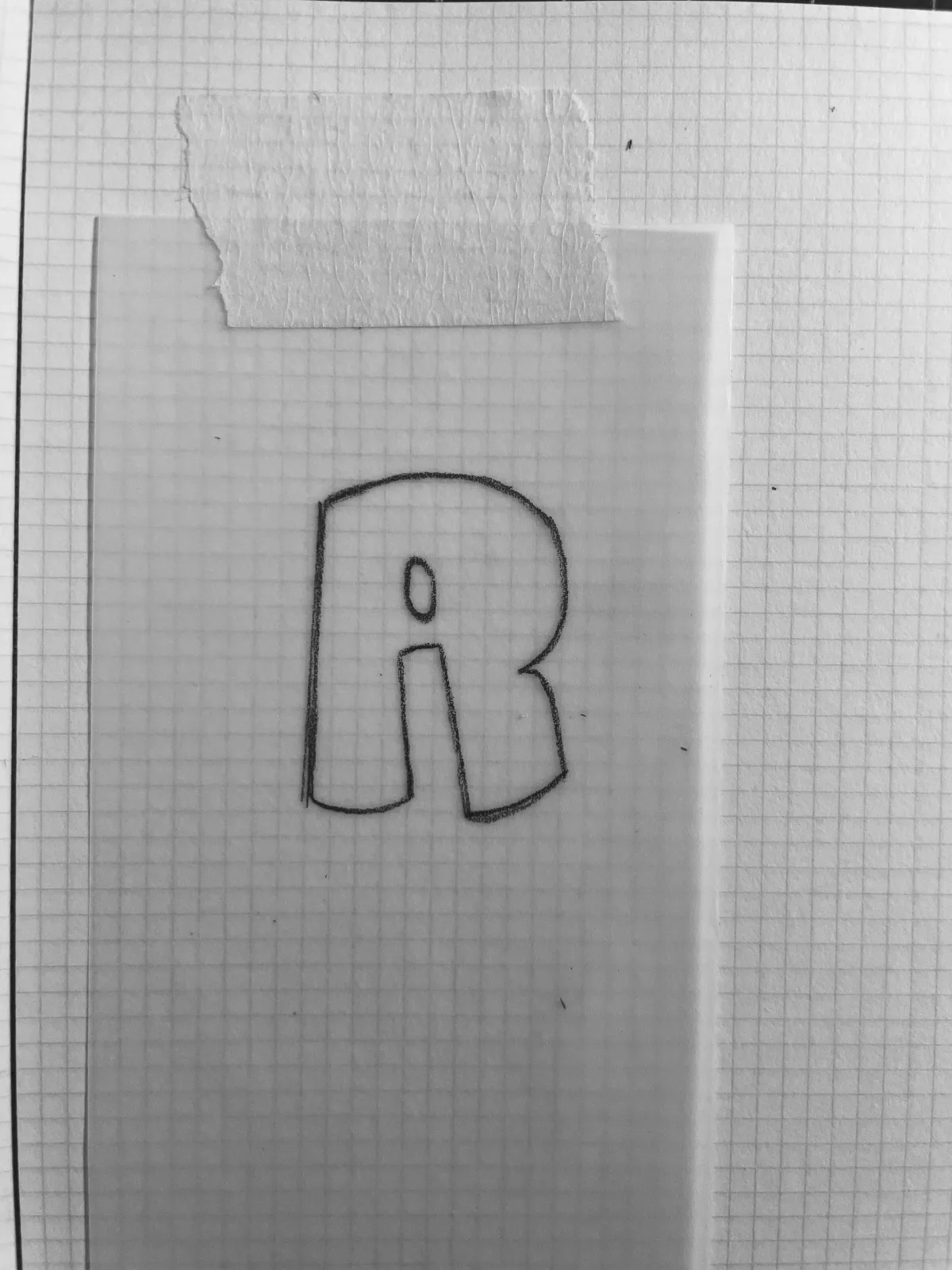 Lettre R dessinée sur papier quadrillé
