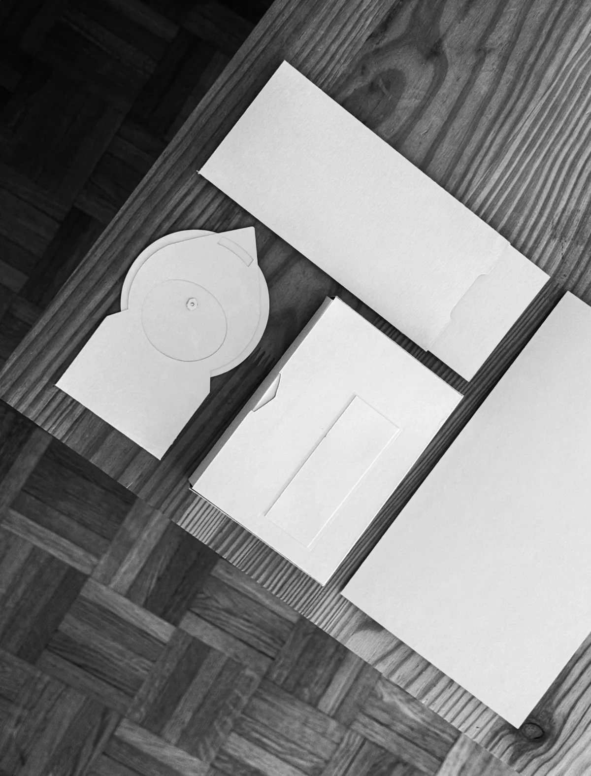 Formes en papier blanc découpées, posées sur un parquet