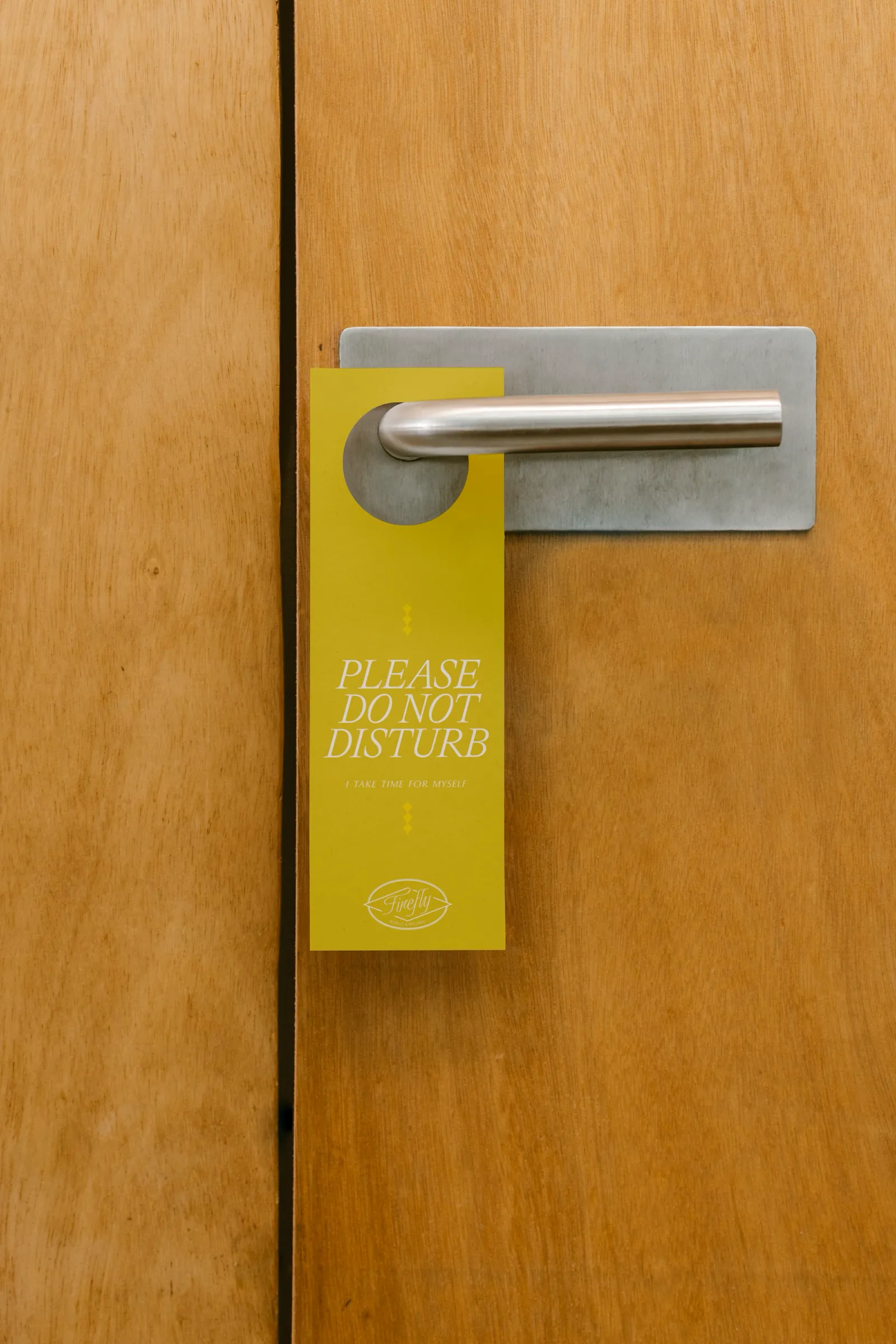 Accroche-porte jaune Firefly suspendu à une poignée de porte en bois