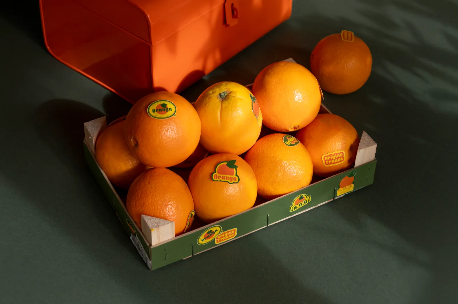 Cagette d’oranges Oranga sur fond vert sombre